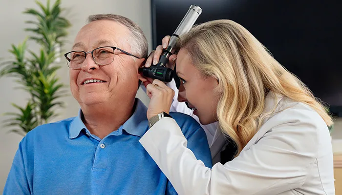 Man having his ears checked by a hearing professional